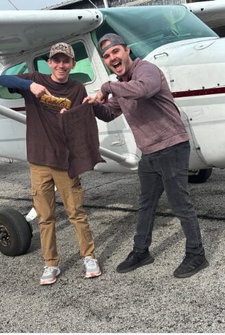 Student celebrating a first solo flight beside a Cessna at Blackstone Aviation